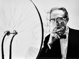 POW-JulianWasser5WASSER Duchamp smoking cigar next to Bicycle Wheel Duchamp Retrospective Pasadena Art Museum 1963